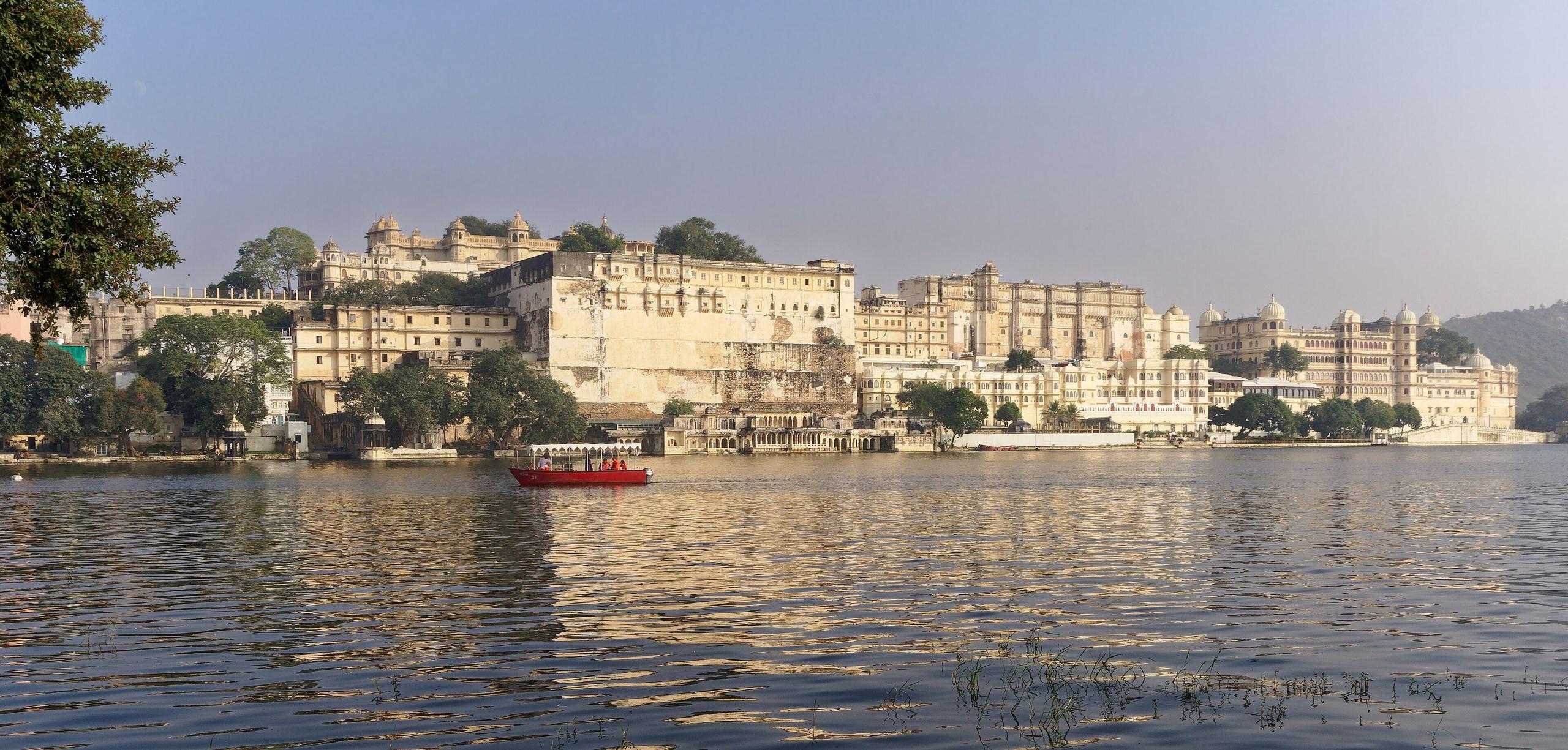 The long frontage of the City Palace over Lake Pichola in Udaipur, in warm afternoon light.